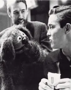  ?? Michael Ochs Archives/ Getty Images ?? Muppets creator Jim Henson, (beard, background), manipulate­s one of his creations as it engages in conversati­on with singer Jimmy Dean in 1963.