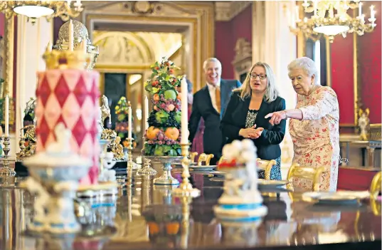  ??  ?? The Queen inspects the exhibition yesterday, guided by Amanda Foreman and accompanie­d by the Duke of York. Top right, the dancing recreation. Bottom right, a baby dress worn by King Edward VII