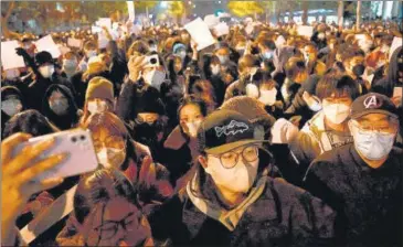  ?? AFP ?? Protesters march along a street during a rally for the victims of a deadly fire as well as a protest against China’s harsh Covid-19 restrictio­ns in Beijing early on Monday.