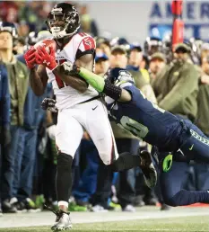  ?? (Reuters) ?? ATLANTA FALCONS receiver Julio Jones (front) catches a long pass as he is tackled by Seattle Seahawks cornerback Jeremy Lane during the second half of the Falcons’ 34-31 road victory on Monday night. Down by 11 late, the Seahawks rallied, but came up...