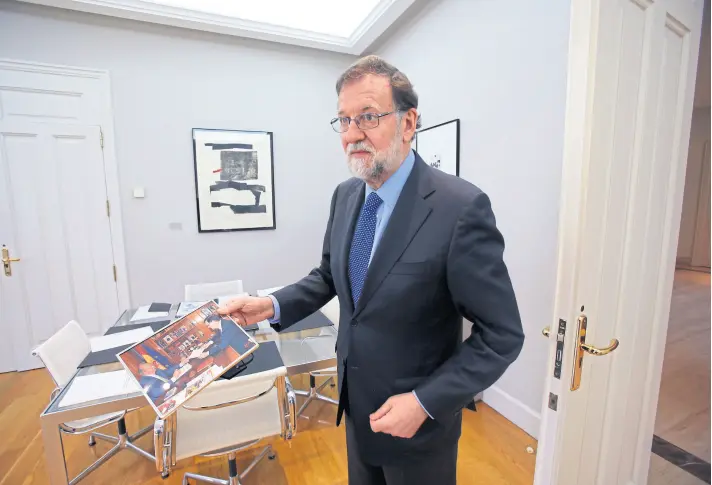  ??  ?? Rajoy en las oficinas de la Moncloa exhibe a la nacion una fotografía donde se lo ve con el rey emérito Juan Carlos