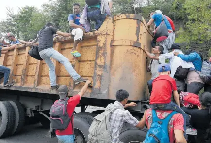  ?? PHOTOS / AP ?? Above: Honduran migrants bound to the US border climb into the bed of a truck in Zacapa, Guatemala. Left: Honduran migrants are taken care of by Guatemalan Red Cross volunteers, in Tecun Uman, Guatemala.