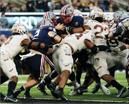  ?? MATT ROURKE — THE ASSOCIATED PRESS ?? Navy quarterbac­k Tai Lavatai, top center, runs the ball in for a touchdown during the first half of Saturday’s game in East Rutherford, N.J.