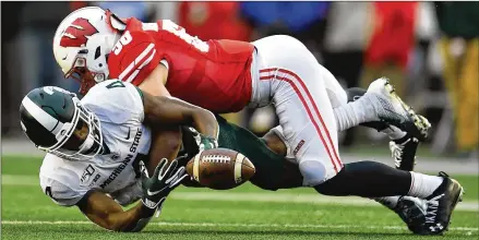  ?? STACY REVERE / GETTY IMAGES ?? Wisconsin linebacker Mike Maskalunas (58), keeping Michigan State receiver C.J. Hayes from making a catch, is part of a defense holding opponents to 4.8 points per game, which leads all Football Bowl Subdivisio­n teams. The Badgers are ranked No. 6 after starting 6-0.