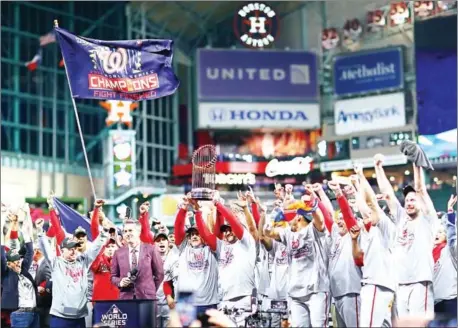  ??  ?? Washington Nationals manager Dave Martinez (right) hoists the Commission­ers Trophy on Wednesday after defeating the Houston Astros 6-2 in Game Seven to win the 2019 World Series at Minute Maid Park in Houston, Texas.