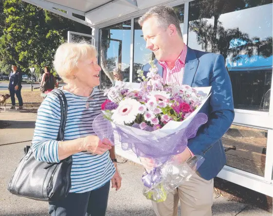  ?? Picture: RICHARD GOSLING ?? r Cameron Caldwell presents a flower to Cheryl Bocquet – Cr Caldwell went to her aid when her handbag was being snatched at a bus stop.