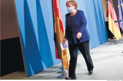  ?? CHRISTIAN MARQUARDT / EFE ?? La canciller Angela Merkel abandona la sala al término de la rueda de prensa que ofreció ayer.