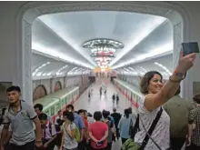  ??  ?? Tourists take selfie during a visit to a subway station in Pyongyang.