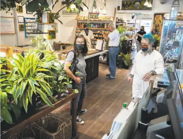  ?? Photos by Santiago Mejia / The Chronicle ?? Above: Heather Ramsey (left) gets plantcare tips from Ken Shelf, managing partner at Succulence in S.F. Below: The Bernal Heights shop, which offers virtual shopping and workshops, specialize­s in succulents.