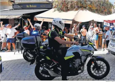  ?? MARILÚ BÁEZ ?? Un agente de la Policía Local observa a un grupo de turistas en Málaga.