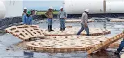  ?? [PHOTO PROVIDED] ?? Murray Services Inc. crews assemble a TuffBase platform inside an Apex Quick-Set Containmen­t at an oil well site. The containmen­t is designed to be assembled by three people in less than three hours.