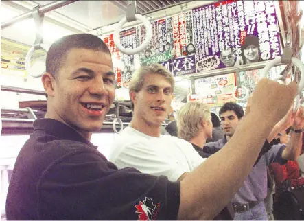  ?? PHOTOS: DAVE OLECKO/FILES ?? Former Flames Jarome Iginla, left, and Cale Hulse (hand onto the handrails) rode the subway train back to their hotel after spending a little time sightseein­g in Tokyo. Valeri Bure and Marty McInnis can be seen background. The Flames opened the 1998 season in the Japanese capital with a pair of games against the San Jose Sharks. This year, the Flames will battle the Bruins in China.