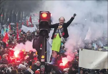  ?? Thibault Camus Associated Press ?? IN PARIS, demonstrat­ors take over a traffic light during a nationwide strike over pension reform. Opponents fear the changes to how and when workers can retire will threaten the hard-fought French way of life.