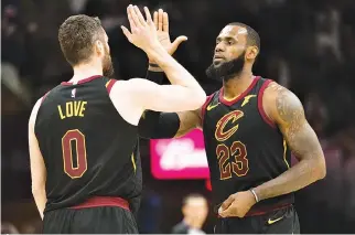  ??  ?? KEVIN LOVE (#0) celebrates with LeBron James (#23) of the Cleveland Cavaliers after Love scored during the first half against the Milwaukee Bucks half at Quicken Loans Arena on March 19 in Cleveland, Ohio.