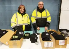  ??  ?? Penny Botkin, left, and Dennis Bashutski sell custom-made caps near the Ramada Hotel in Emerald Park as the convoy stops for the night Thursday.