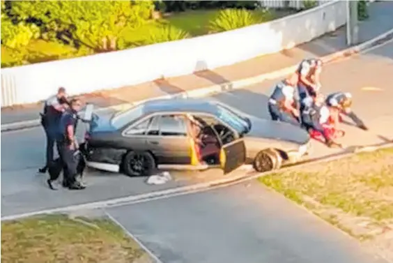  ?? Photo / Mathew Roberts ?? A still from a video filmed from a balcony on Evelyn Couzins Ave shows police working on the badly injured man after the shootout.