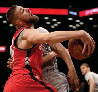  ?? ELSA/GETTY IMAGES ?? Raptor Jonas Valanciuna­s was shut out in the first half, but helped out in other ways in Brooklyn.