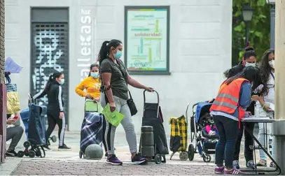  ?? AP ?? Varias personas esperan para recibir alimentos de una parroquia en Puente de Vallecas, en Madrid