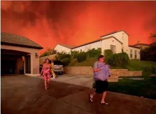  ?? AFP ?? Residents flee their home as flames from the Sand Fire close in near Santa Clarita, California. —