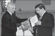  ?? BJOERN SIGURDSOEN/NTB/POOL VIA AP ?? John Hume, right, looks at the Nobel Peace Prize diploma that he received from Francis Sejersted, chairman of the Norwegian Nobel Peace Prize Committee, during a Dec. 10, 1998, award ceremony in Oslo Town Hall. Hume, who won Nobel Peace Prize for work to end violence in Northern Ireland, has died at age 83.