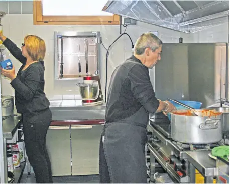  ??  ?? Pierrette Bertrand prépare les repas de la cantine scolaire avec l’aide de Chloé Bresson.