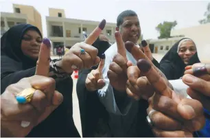  ?? (Alaa al-Marjani/Reuters) ?? PEOPLE SHOW their ink-stained fingers after voting in Najaf, 160 km. south of Baghdad, yesterday.