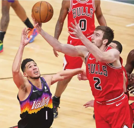  ?? JONATHAN DANIEL/GETTY IMAGES ?? Bulls backup center Luke Kornet grabs a rebound over Suns guard Devin Booker during the first half Friday at the United Center.