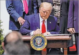  ?? Evan Vucci The Associated Press ?? President Donald Trump signs the Paycheck Protection Program Flexibilit­y Act during a news conference June 5 in the Rose Garden of the White House.