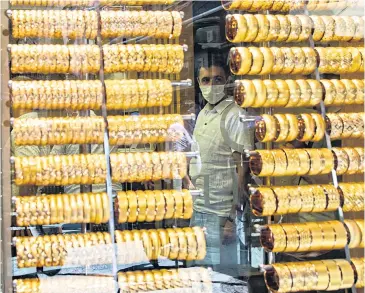  ?? AFP ?? A man stands behind a gold shop window in Istanbul.