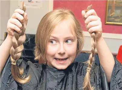  ?? Pictures: Angus Findlay. ?? Lewis, 8, holds his chopped hair. Below: in helping the charity, Lewis had to put up with being mistaken for a girl.