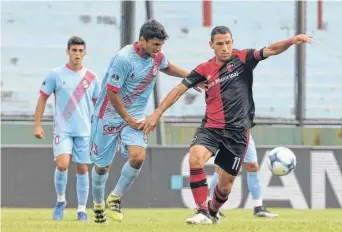  ??  ?? Con habilidad, Maxi Rodríguez procura escaparle a la marca de Leandro Marín.