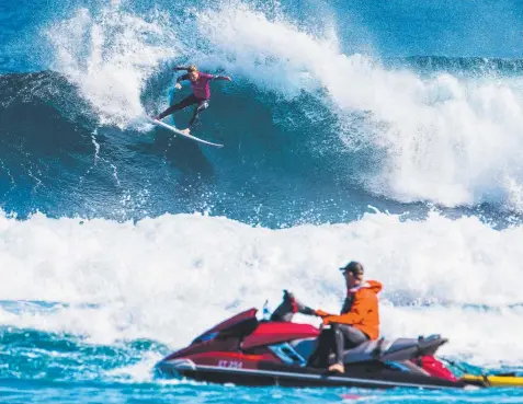  ?? Picture: WSL ?? DANGER ZONE: A shark-spotter watches Nikki Van Dijk at the Margaret River Pro, which was cancelled yesterday.