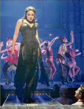  ?? Sara Krulwich / New York Times ?? Above, Karen Olivo as Satine in “Moulin Rouge! The Musical” at the Al Hirschfeld Theater in New York City in 2019. Below, people wait at an intersecti­on on W 51st Street in Manhattan earlier this year.