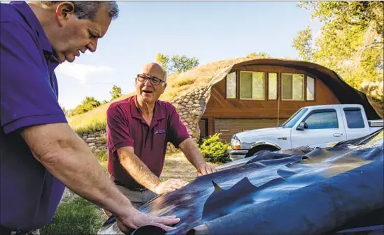  ?? Photograph­s by Isaac Hale For The Times ?? MERRELL and Overton, left, compare two kinds of leather on the hood of Overton’s SUV to decide which will be used to make the attorney’s custom hiking boots.