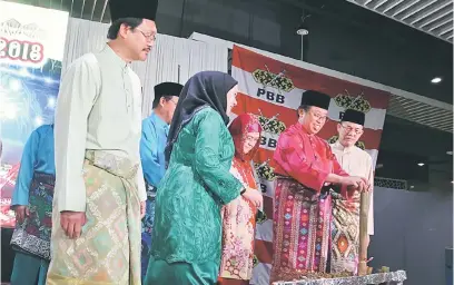  ??  ?? SIMBOLIK: Abang Johari mengambil lemang sebelum dipotong sebagai simbolik Majlis Gawai Raya PBB Zon Kuching 2018. Turut kelihatan isteri beliau, Datin Patinggi Datuk Juma’ani Tuanku Bujang (tiga kanan), Hasidah (dua kiri), Fadillah (kanan) dan Ahli...