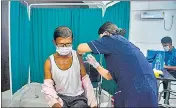  ??  ?? A health worker inoculates a beneficiar­y with the jab of Covishield vaccine in Siliguri on Sunday