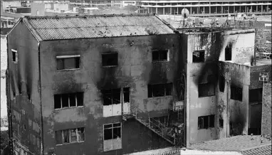  ??  ?? General view taken of a burned warehouse where up to 200 migrants lived in squalid conditions. (Photo: RT)