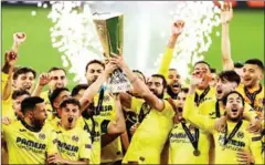  ?? AFP ?? Villarreal’s players celebrate with the trophy after winning the UEFA Europa League final football match against Manchester United on May 26.