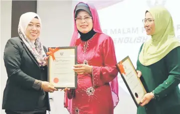  ??  ?? Fatimah (centre) presents a certificat­e of appreciati­on to one of the participan­ts.