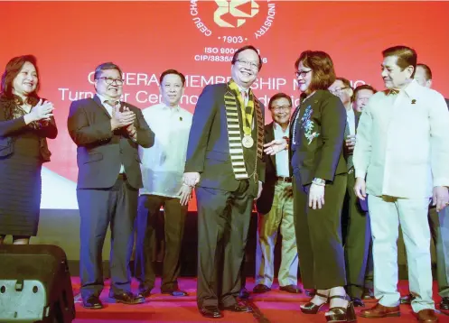  ?? SUNSTAR FOTO / ARNI ACLAO ?? TURNOVER. Melanie Ng (right) turns over the presidenti­al medallion to new CCCI president Antonio Chiu at a ceremony last week, as past presidents look on.