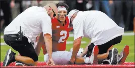  ?? Nati Harnik ?? The Associated Press Nebraska trainers examine Adrian Martinez after the quarterbac­k was injured in the fourth quarter of the Cornhusker­s’ 33-28 loss to Colorado on Saturday.