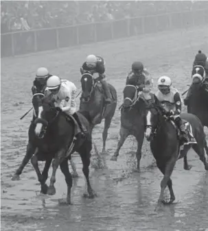  ?? Getty Images ?? Justify, ridden by jockey Mike Smith, crosses the finish line to win the 143rd running of the Preakness Stakes at Pimlico Race Course on a sloppy, foggy Saturday. Justify, winner of the Kentucky Derby, needs to take Belmont to capture the Triple Crown.