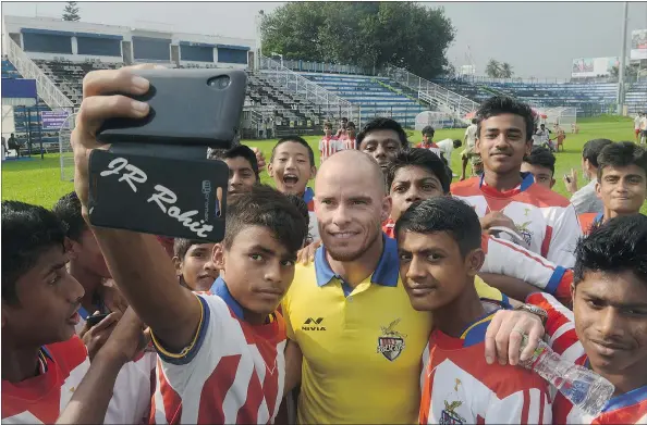  ?? — PHOTOS: GETTY IMAGES FILES ?? Iain Hume, centre, a Canadian internatio­nal for the Atletico Kolkata team, poses for a selfie with junior football players at Kanchajung­ha Stadium in Siliguri, India, on Sept. 26, 2015. Hume, 32, rose to stardom during a stint in the Indian Super League.