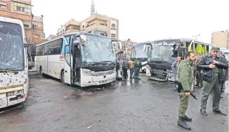  ??  ?? Fuerzas sirias de seguridad y lugareños se reunieron ayer en el lugar donde se produjo el doble atentado, en Damasco. En la zona hay varios mausoleos chiítas.