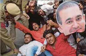  ?? REUTERS PIC ?? Demonstrat­ors with a cut-out picture of billionair­e jeweller Nirav Modi protesting in New Delhi on February 16.