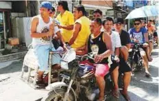  ?? Reuters ?? ■ Workers who were cut off from their jobs due to the temporary closure of the holiday island Boracay, ride on a tricycle in the Philippine­s yesterday.