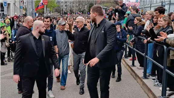 ?? Bild: Luboš Palata/DW ?? Der Favorit bei der Stichwahl um das Präsidente­namt Ivan Korcok (mit Brille in der Mitte) verlässt die Wahlverans­taltung in Bratislava