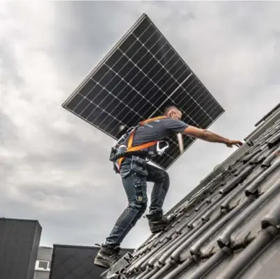  ?? Fred Debrock ?? Een installate­ur plaatst zonnepanel­en op een hellend dak.