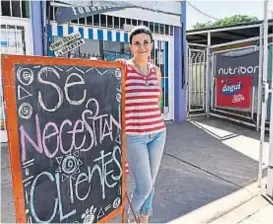  ?? (RAMIRO PEREYRA) ?? Original. Andrea, junto al cartel que colocó frente a su local.