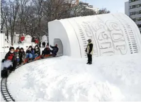  ?? AFP ?? People ride a mini steam locomotive through the ‘Cup Noodles and Rui Hachimura's snow tunnel’ during the Sapporo Snow Festival in Sapporo.